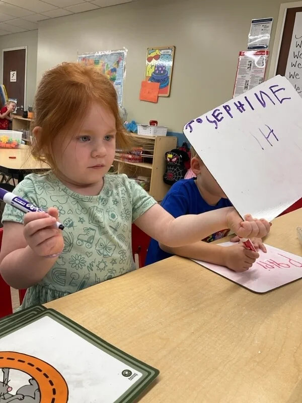 pre-kindergarten kids practice writing their names