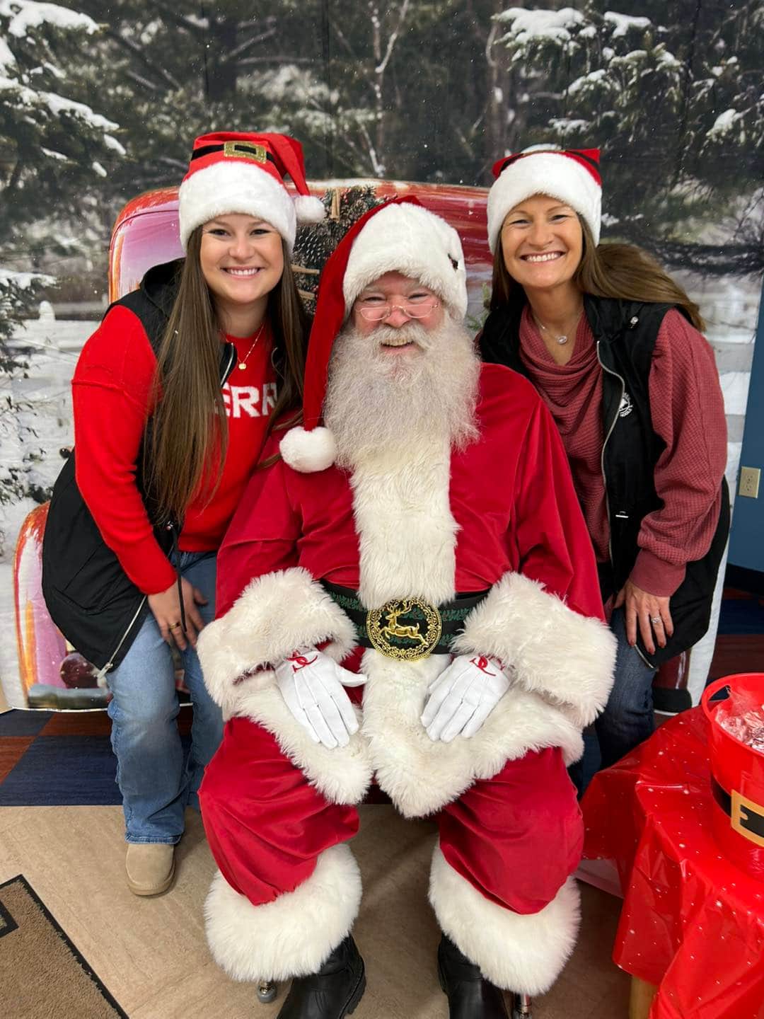 2 adults standing with santa