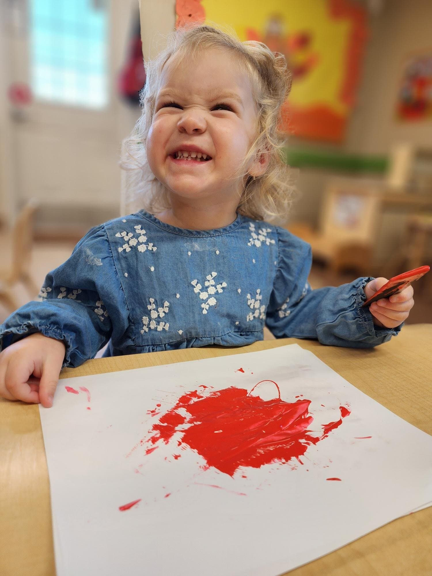 Toddler painting in small group to explore textures and fine motor skills