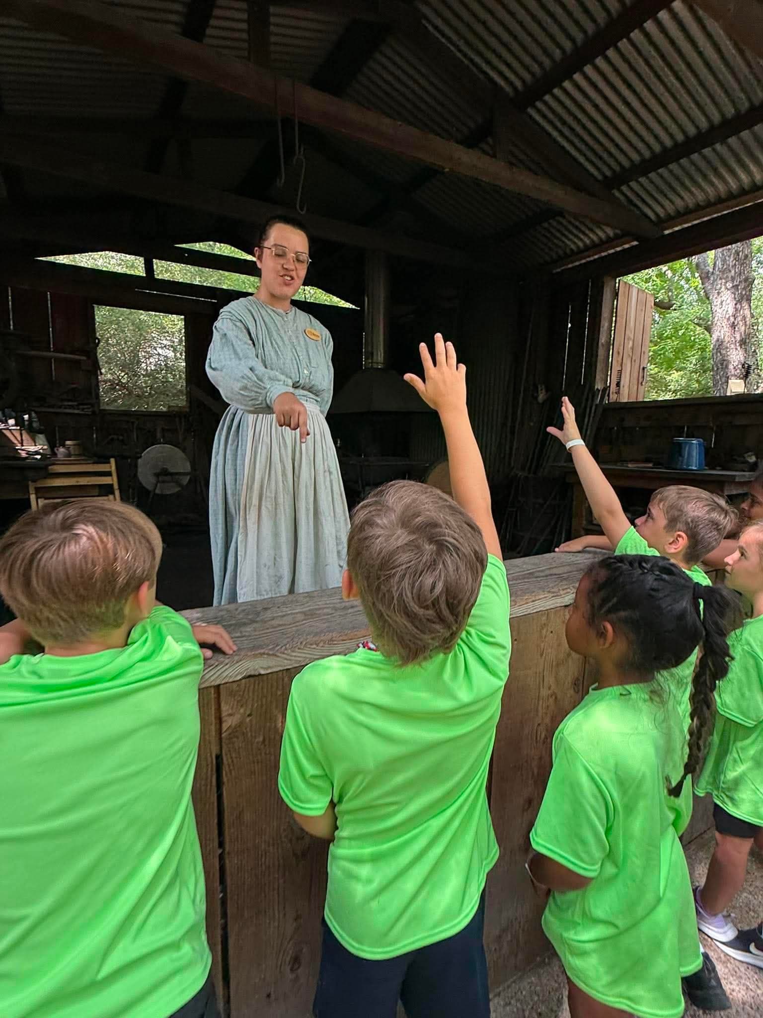 Explorers on a field trip raising their hands answering questions