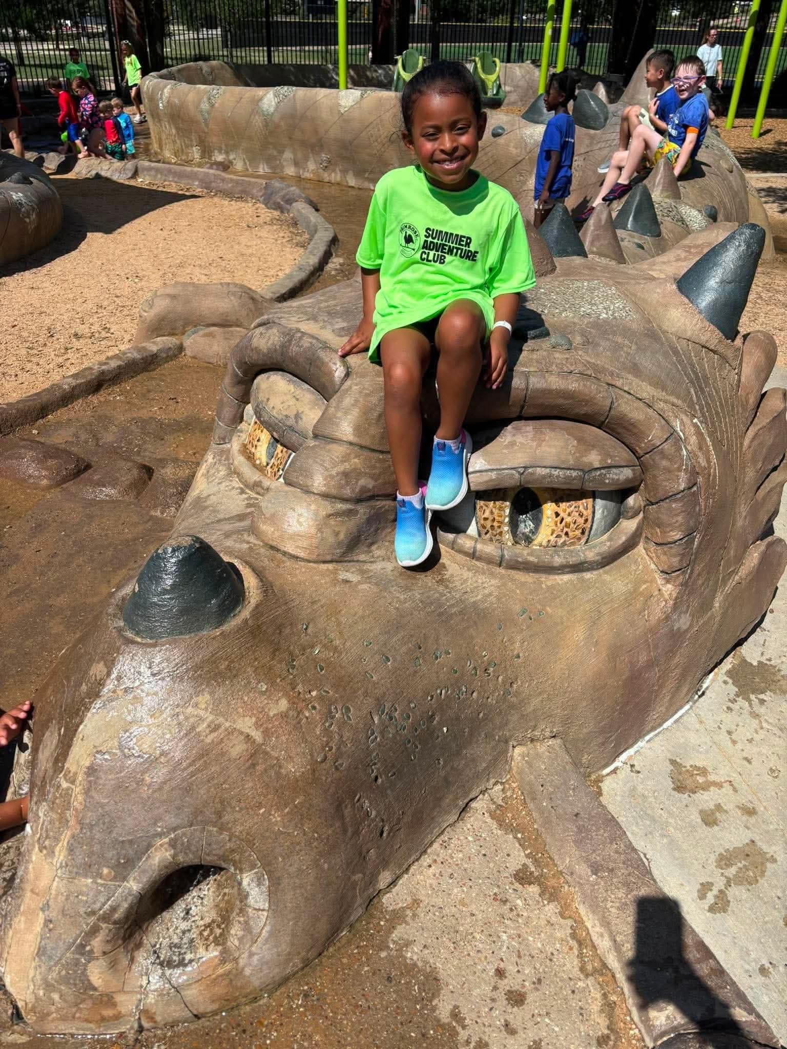 little girl sitting on top of dragons head