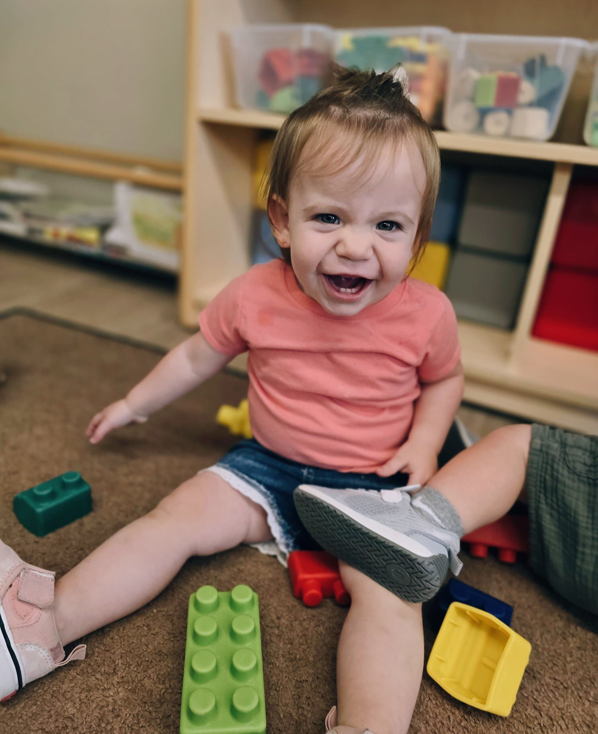 Smiling toddler child playing with blocks during center time at Primrose School at Heritage in Fort Worth, Texas.