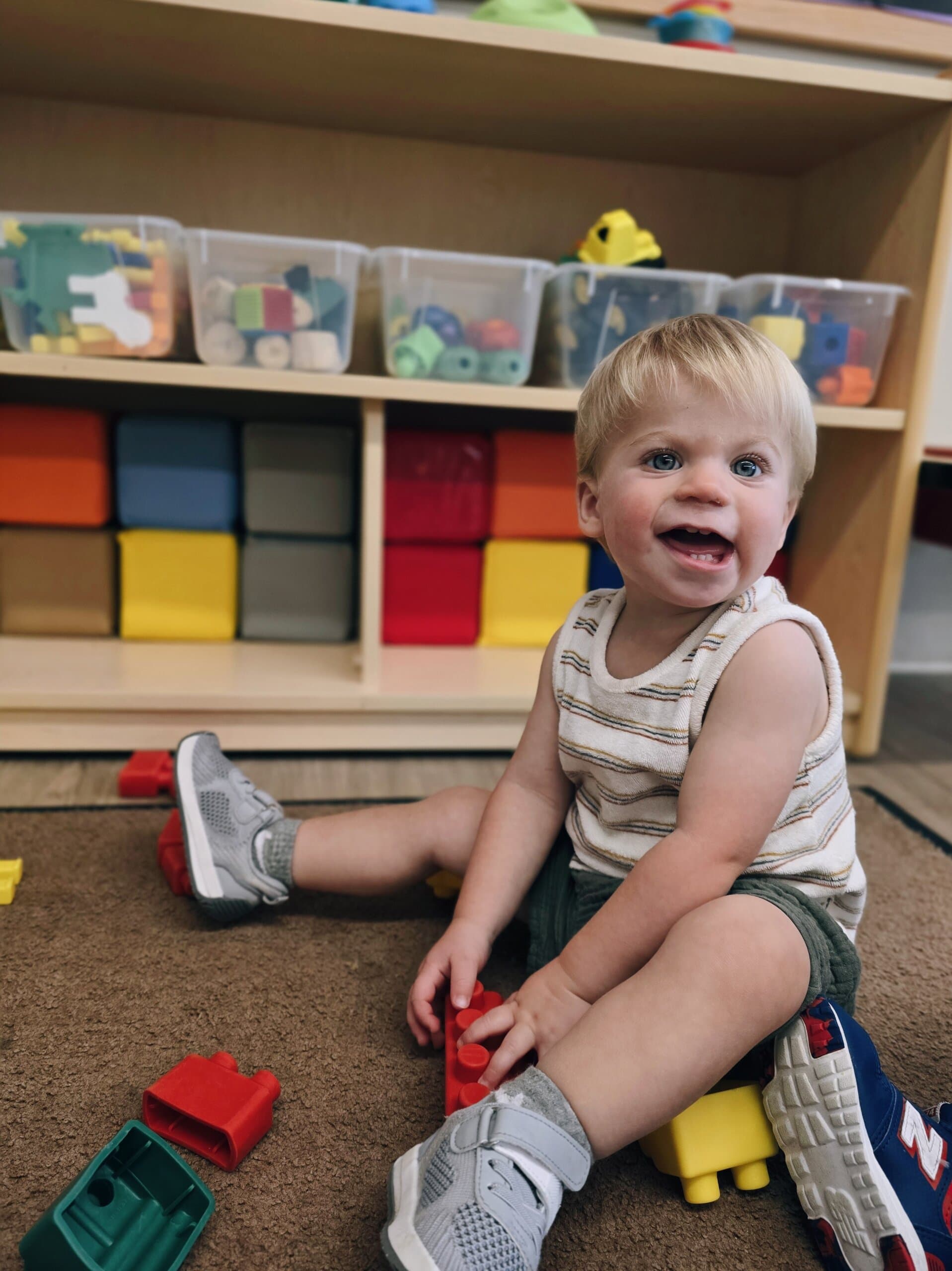 Smiling toddler child playing with blocks during center time at Primrose School at Heritage in Fort Worth, Texas.