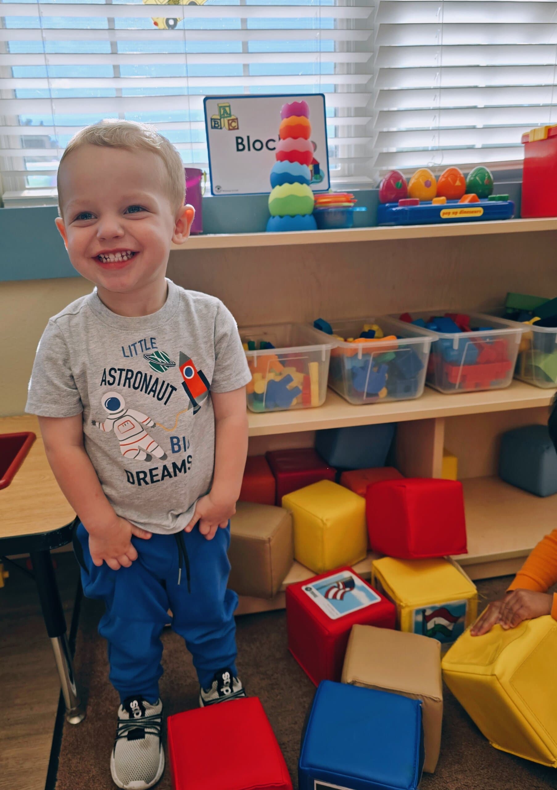 Smiling toddler child playing with blocks during center time at Primrose School at Heritage in Fort Worth, Texas.