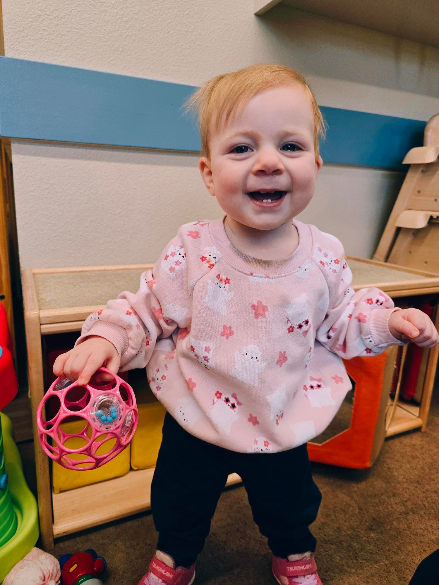 Infant playing with ball in classroom.