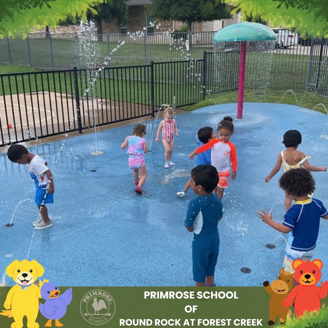 Children enjoying Splash Day at Primrose School of Round Rock at Forest Creek, playing in the outdoor splash pad during summer activities.