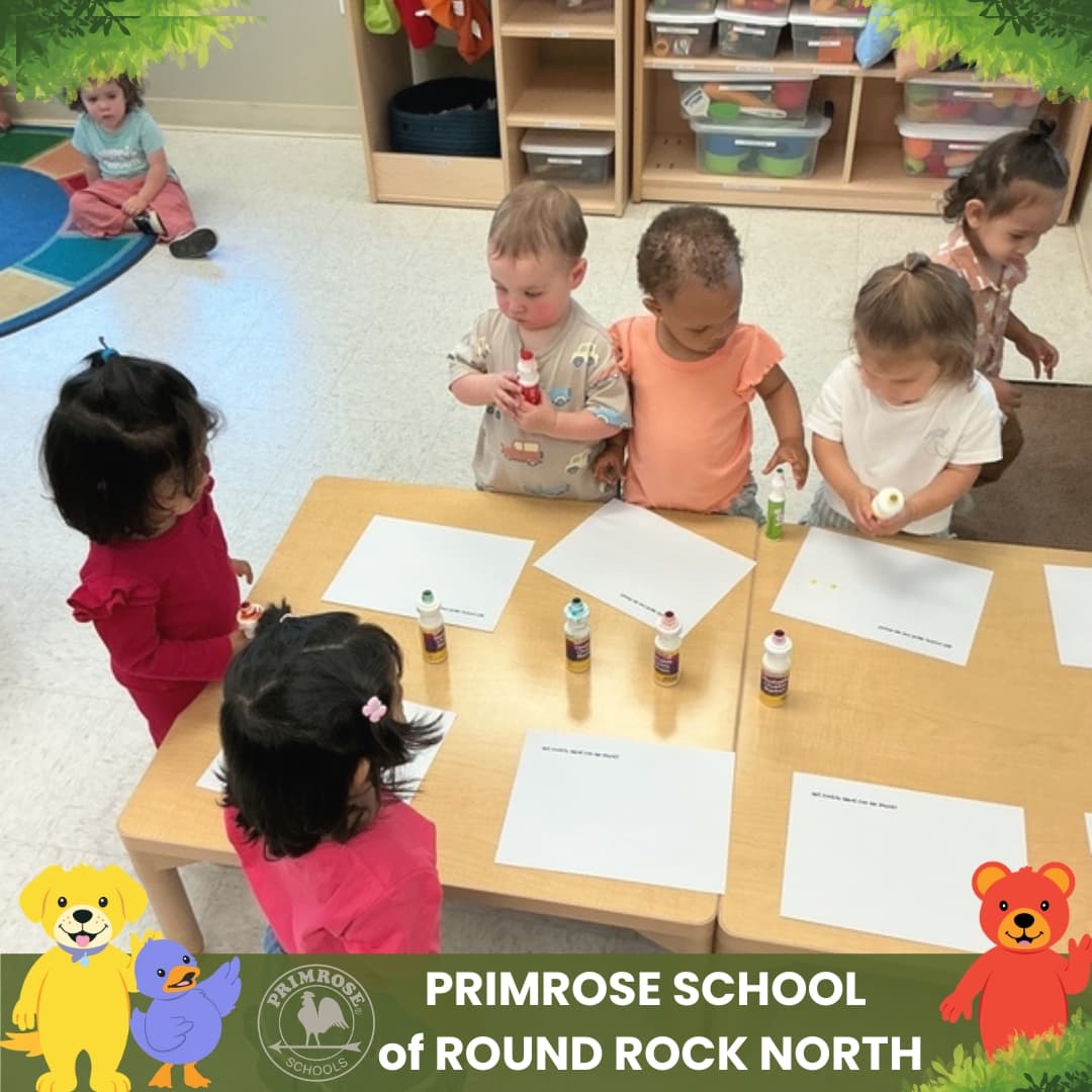 Toddlers at Primrose School of Round Rock North participating in a colorful classroom painting activity.