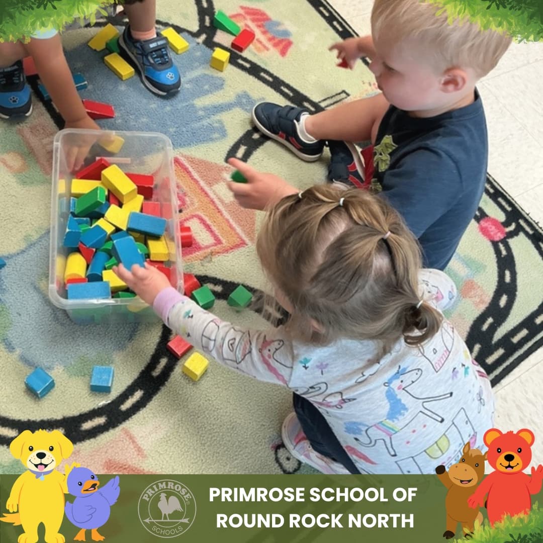 Preschool children at Primrose School of Round Rock North building with colorful blocks during a hands-on learning activity.