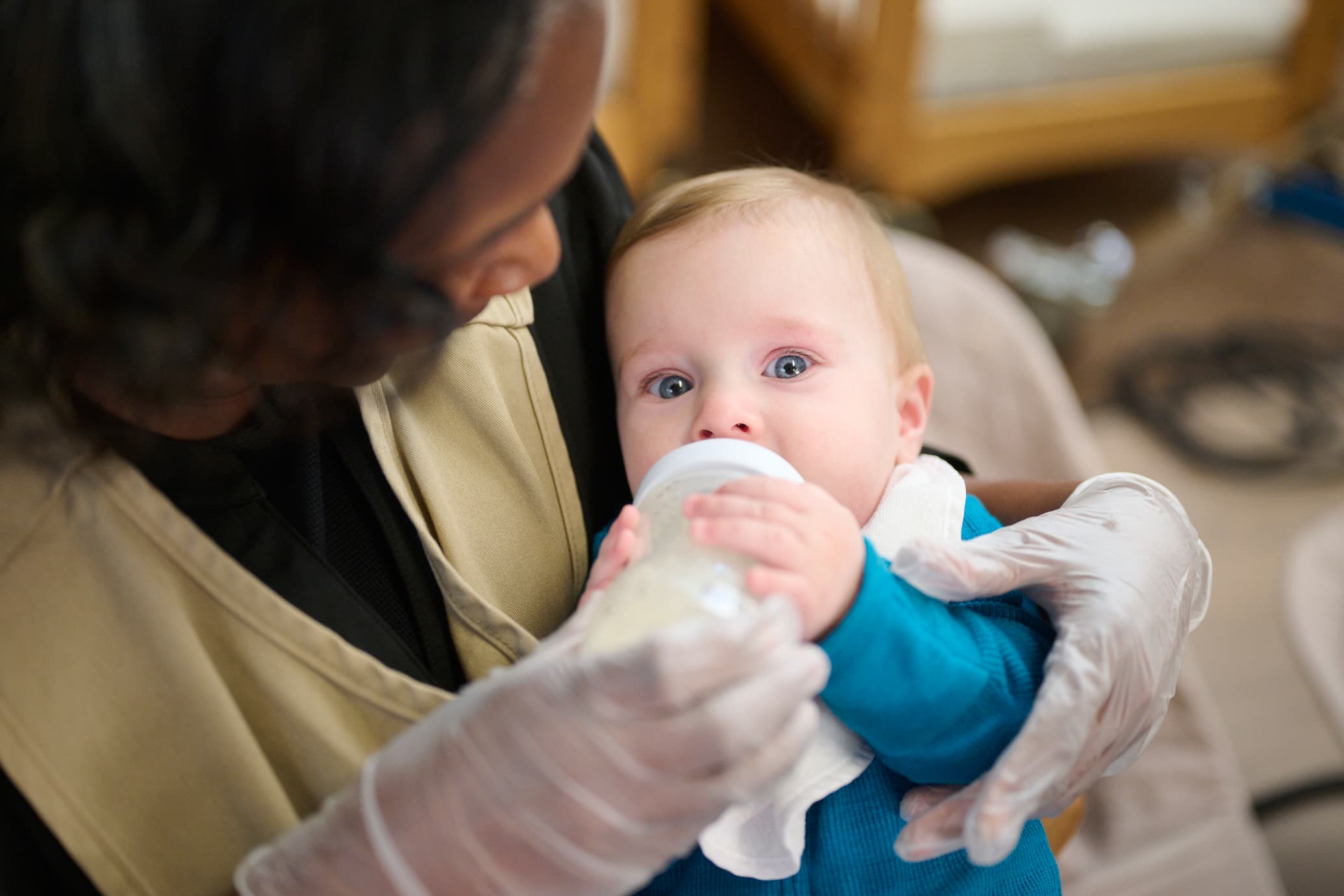 Teacher feeding infant a bottle