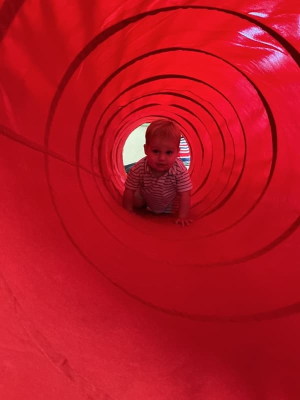 child crawling through a tunnel in the classroom