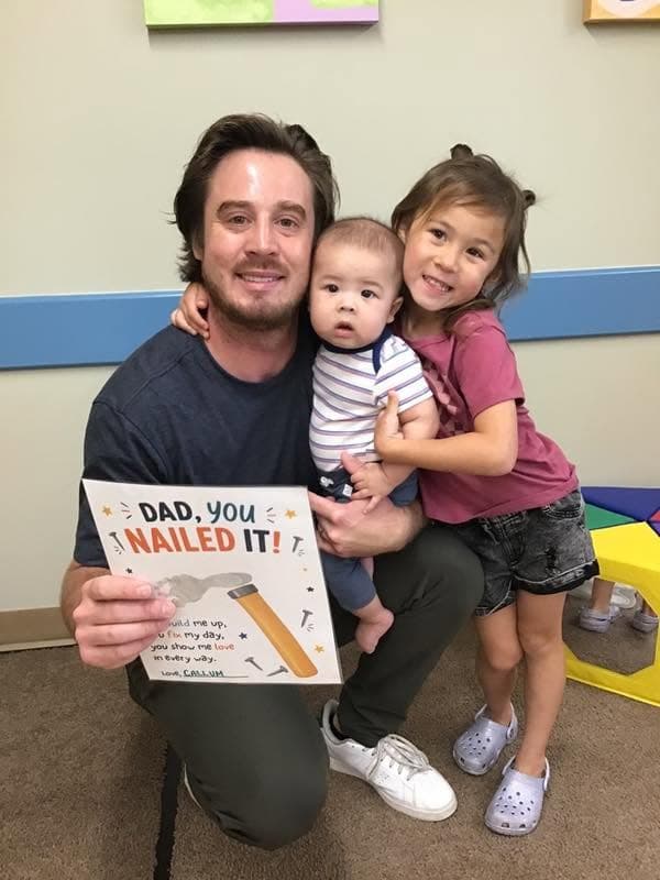 A dad posing for a picture with his two children for fathers day.