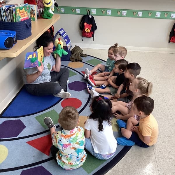 Preschoolers participating in Circle Time routines while using puppets. 