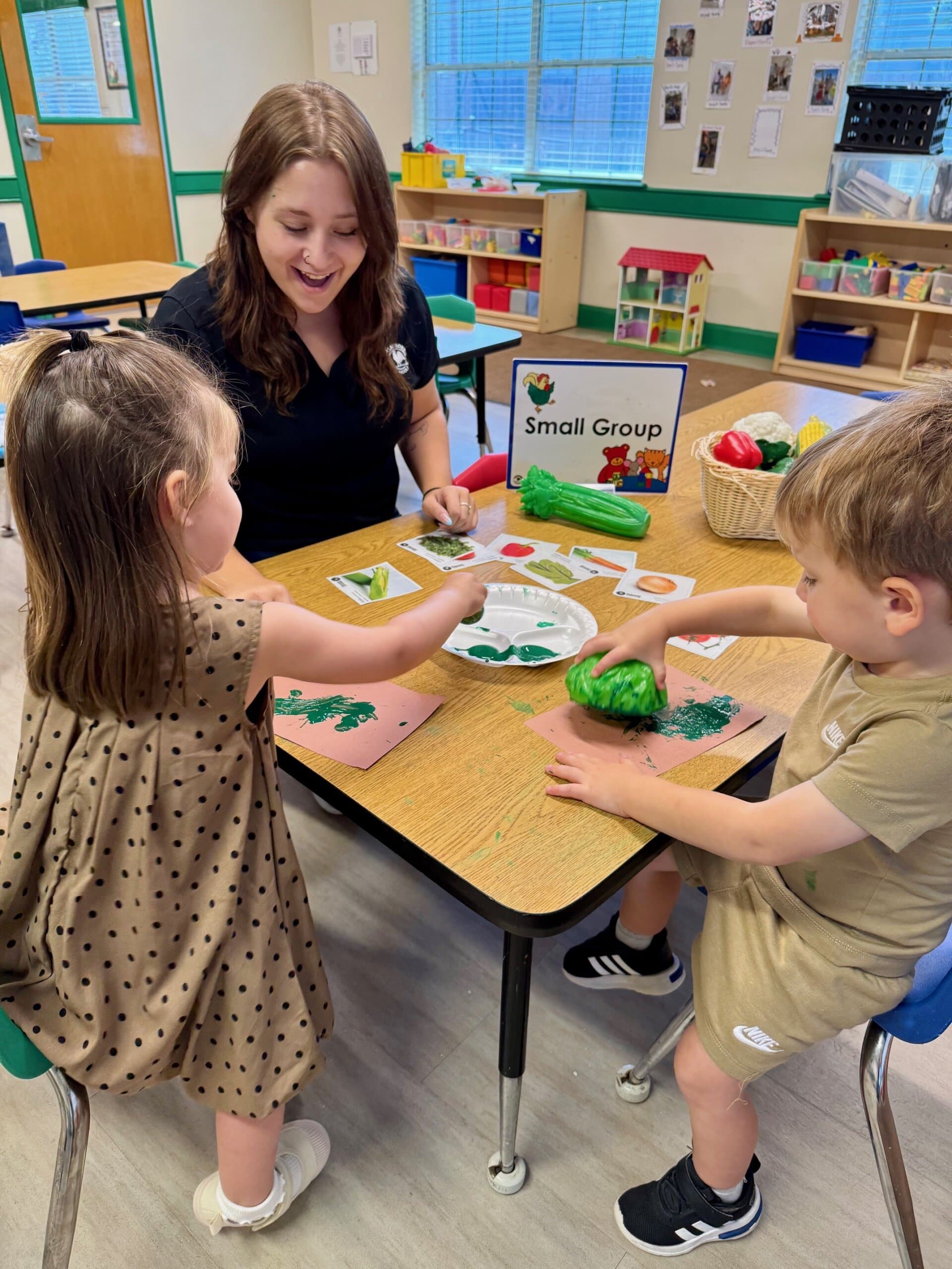 Preschool students participating in a small group activity, identifying different fruits by name and color, promoting early learning and social interaction