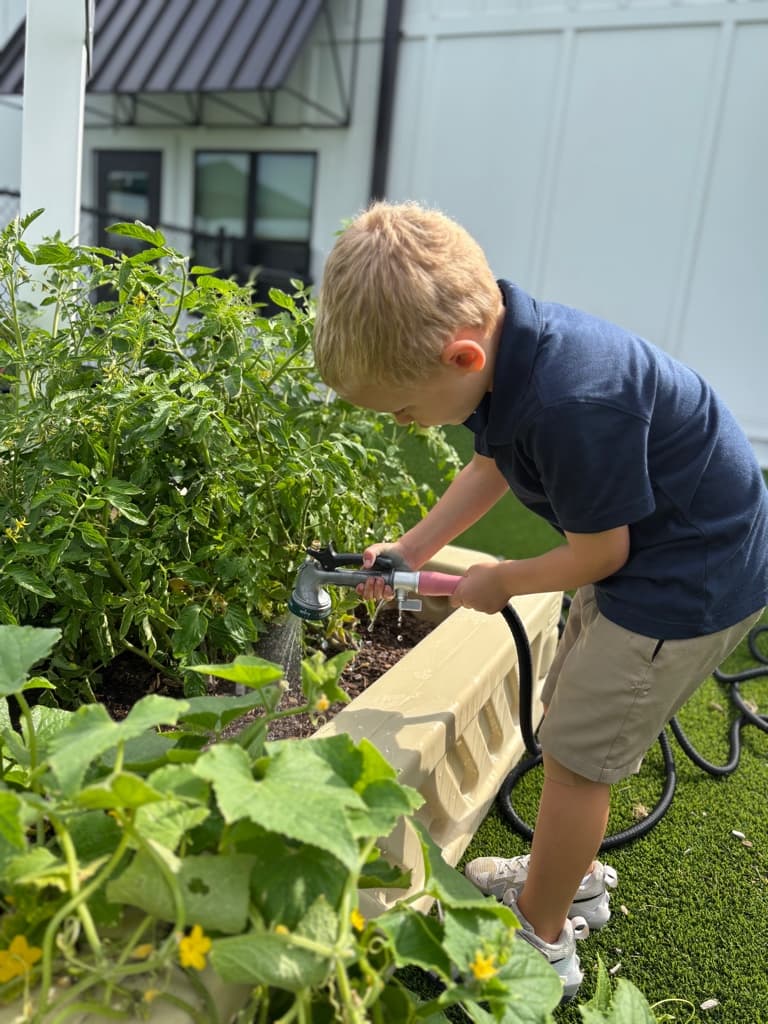 child watering a garden