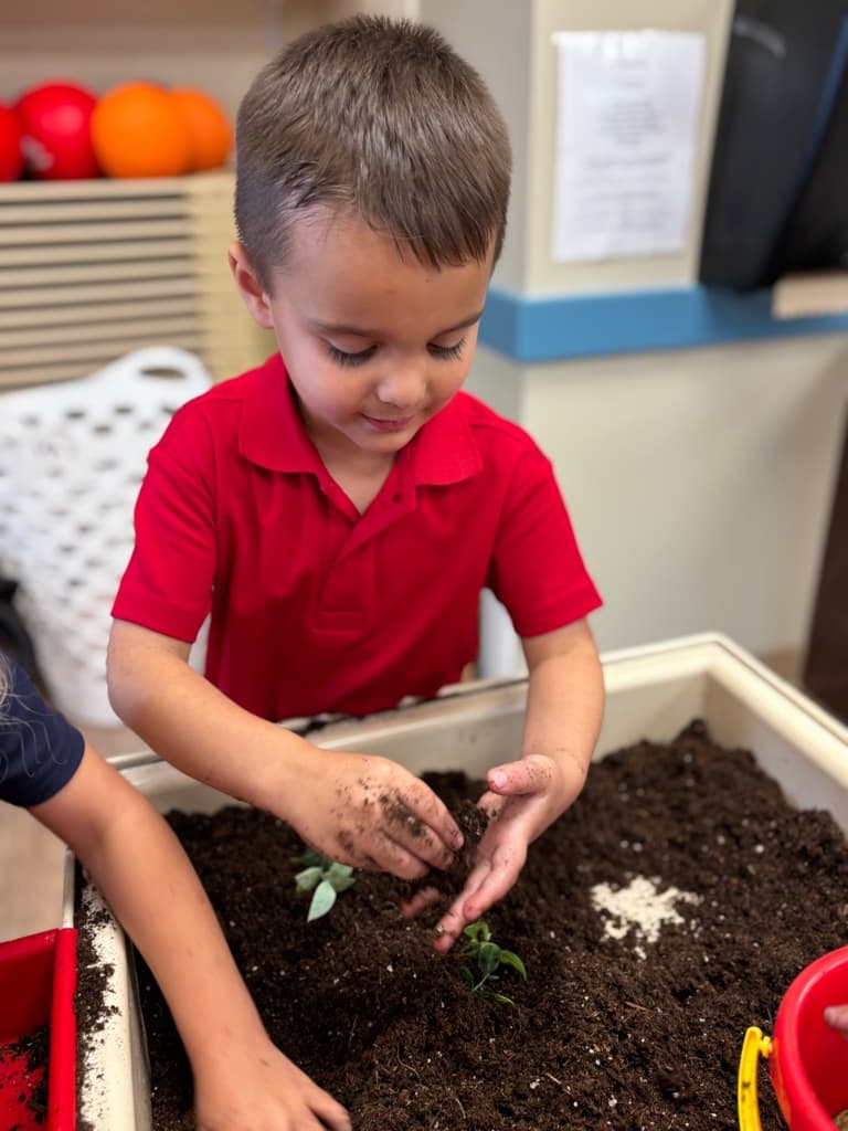 child playing with dirt in sensory table