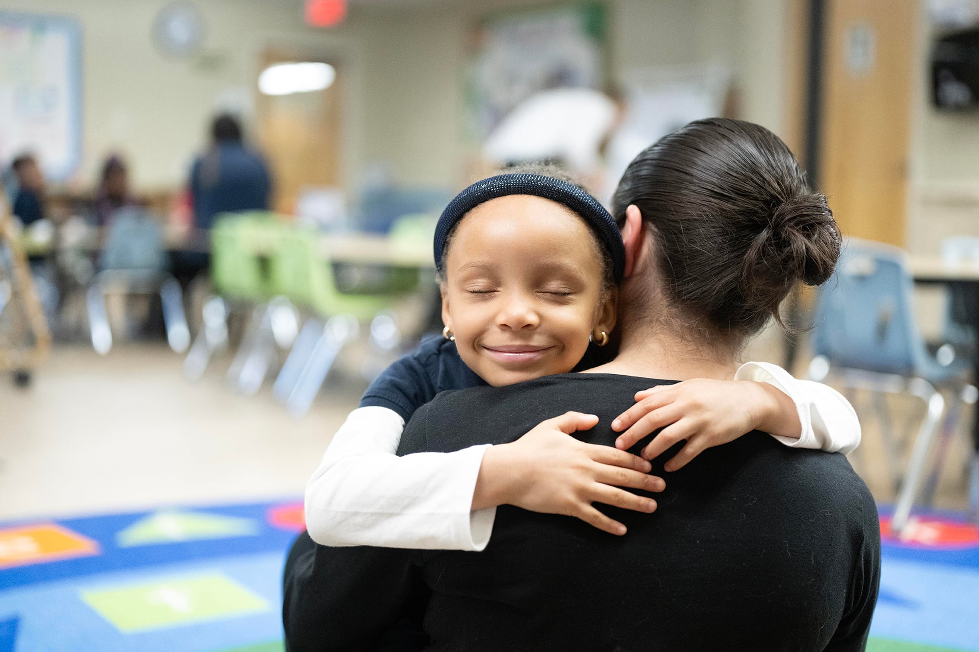 student and teacher hugging