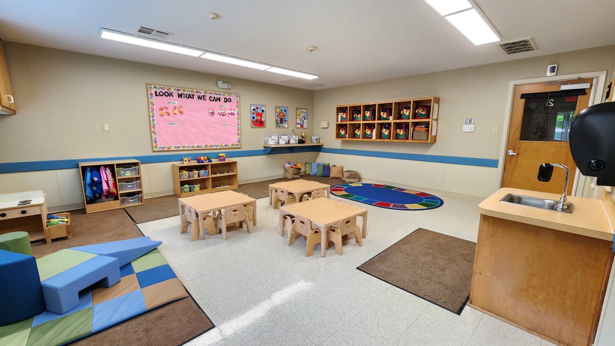 "Young Toddler Classroom, Neatly arranged safe tables and chairs, Colorful Play Equipment, and Stimulating Early Childhood Development Activities"