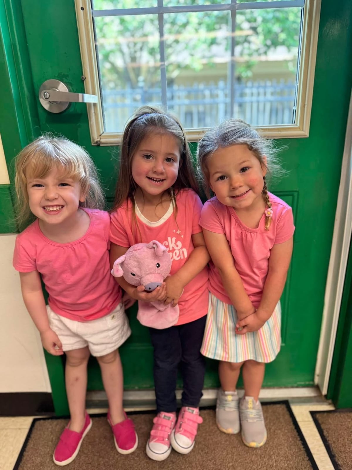 children wearing pink, holding puppet, daycare, learning