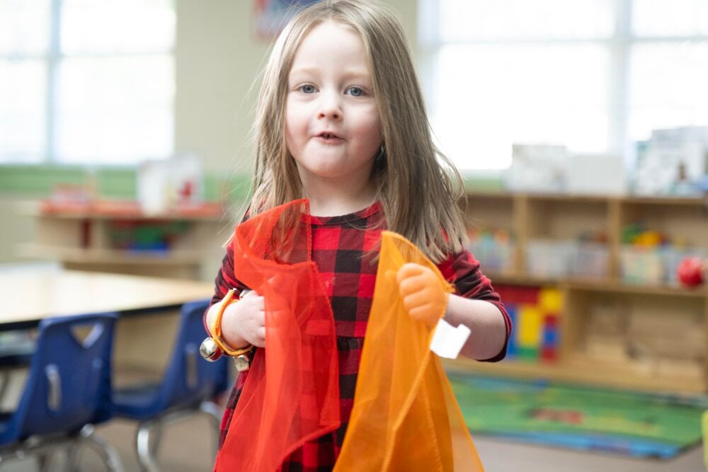 preschool child holding scarves