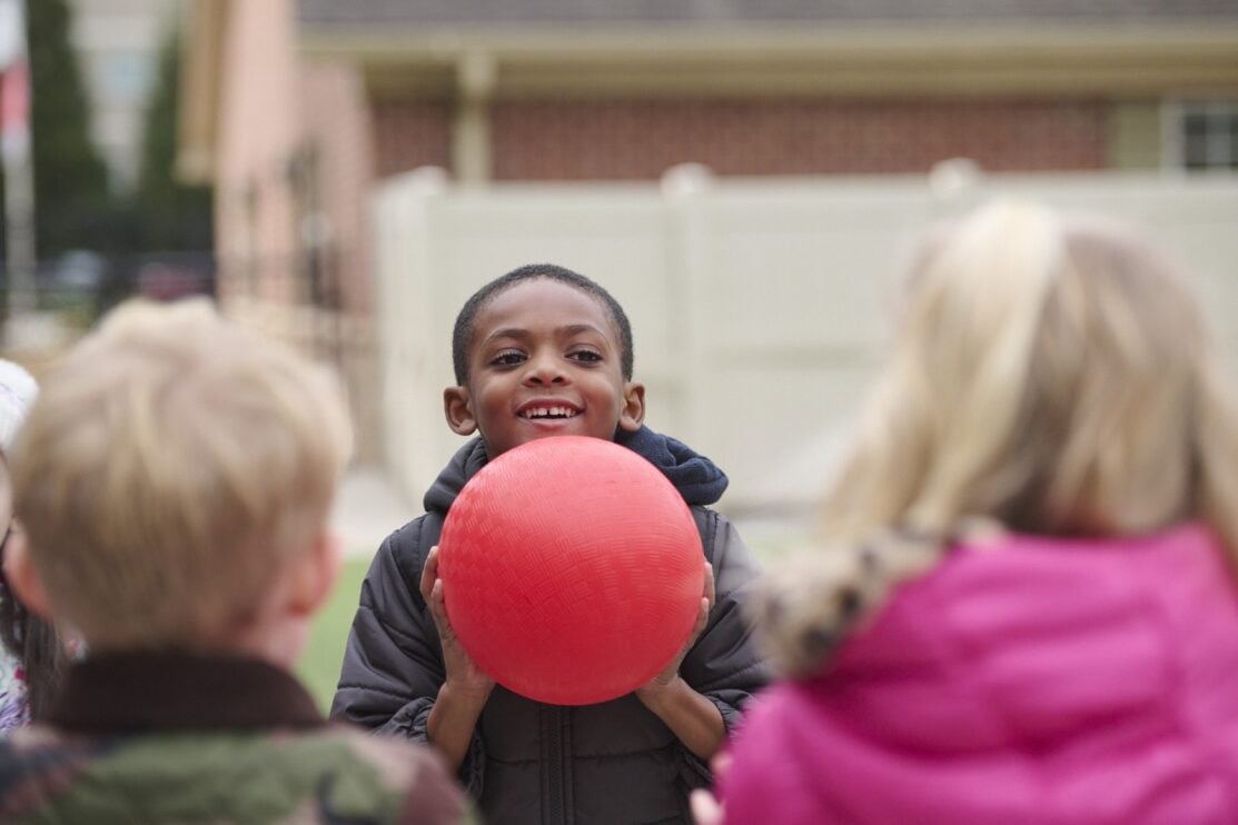 kindergarten child holding a ball