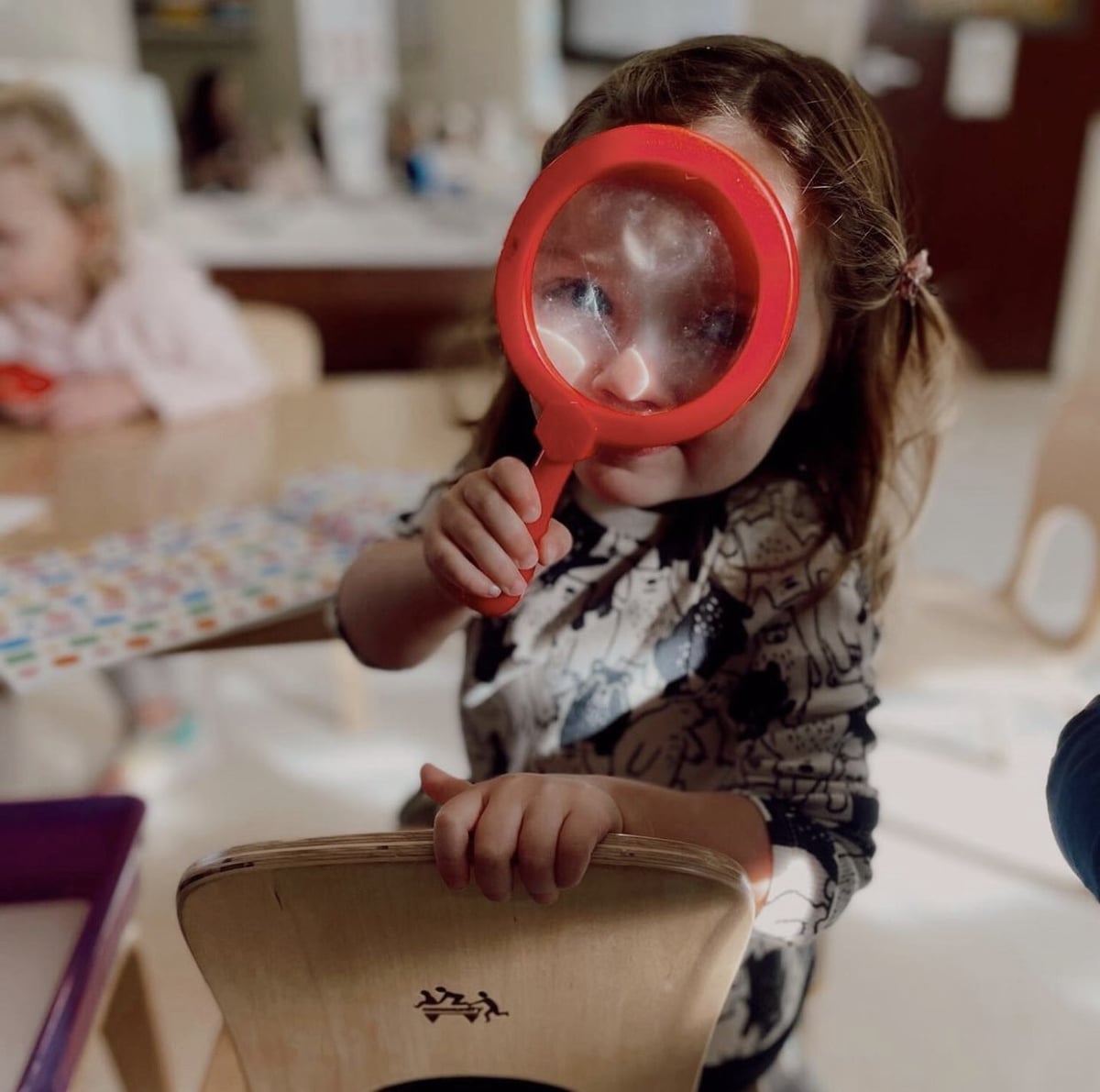 Student looking through magnifying glass