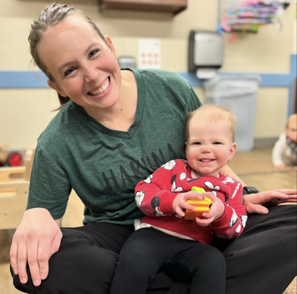 Teacher holding infant in lap