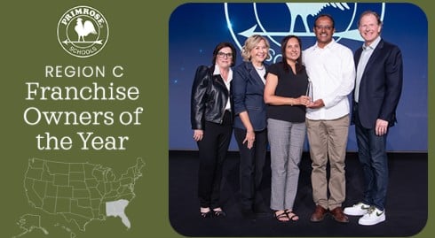 three women two men standing on a stage accepting an award
