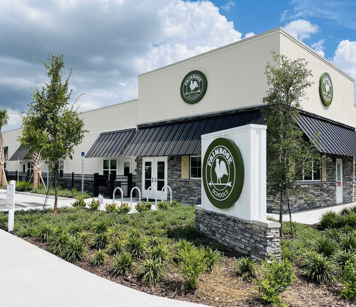 outside of building with parking lot, palm trees and primrose logo