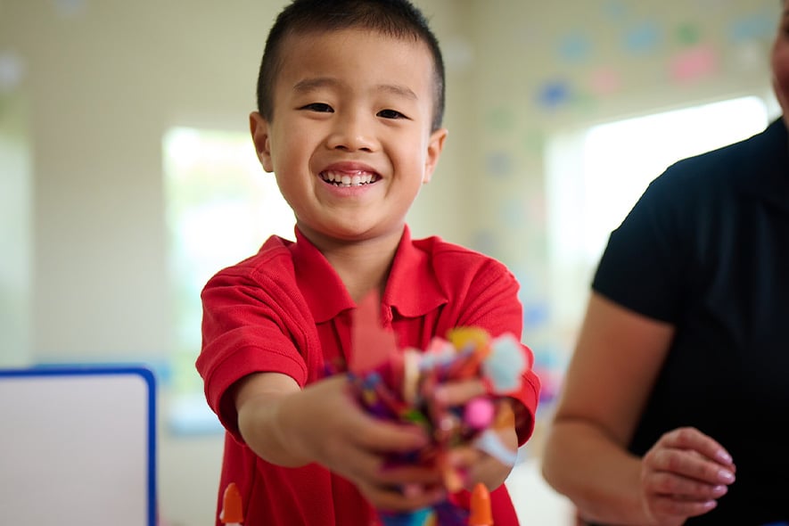 young boy sharing with classmates