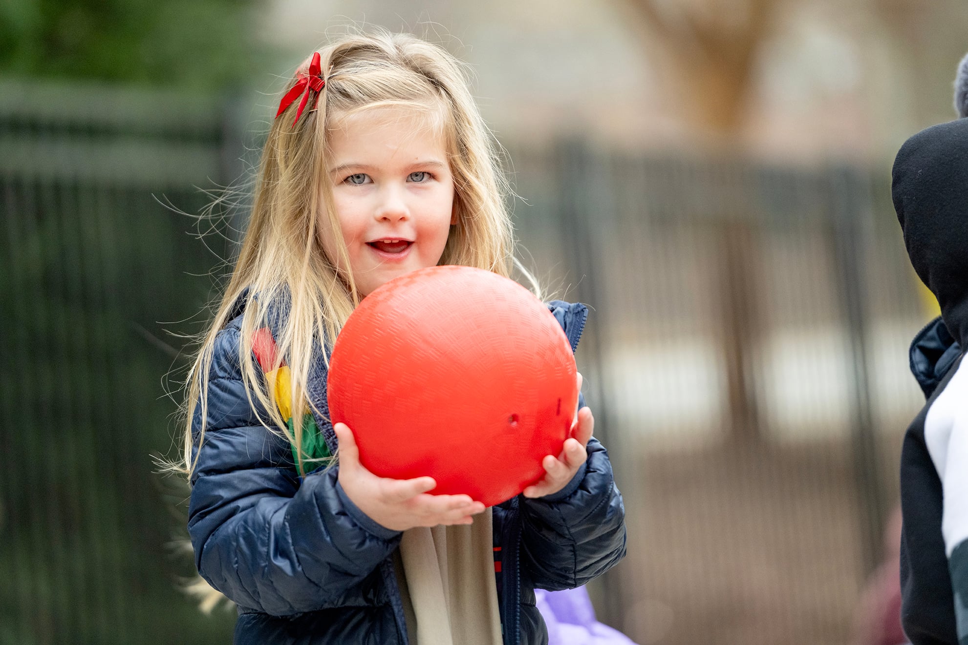 pre-k student playing with ball at recess