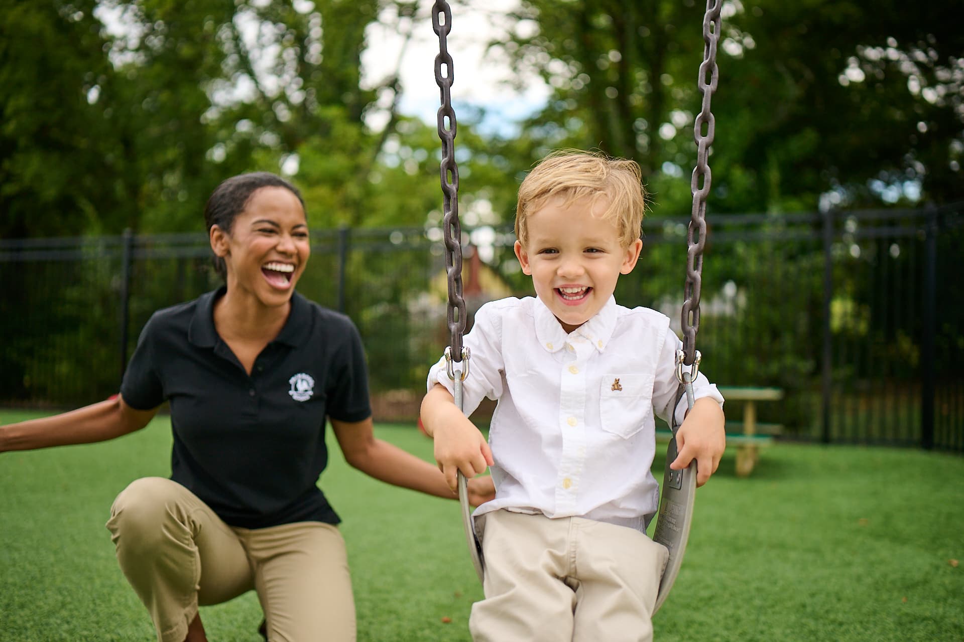 teacher and child playing on the swing