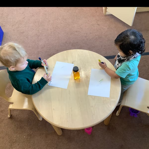 Children sitting at atable with paper and crayons