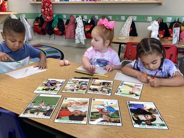 Early Preschool kids doing small group instruction learning routines at Eagle Ranch preschoo,.