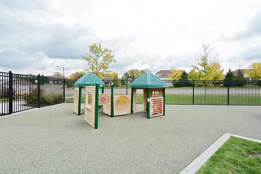 Toddler playground at Primrose School of Eagan featuring double play structures with green roofs, interactive panels, and rubber safety surfacing
