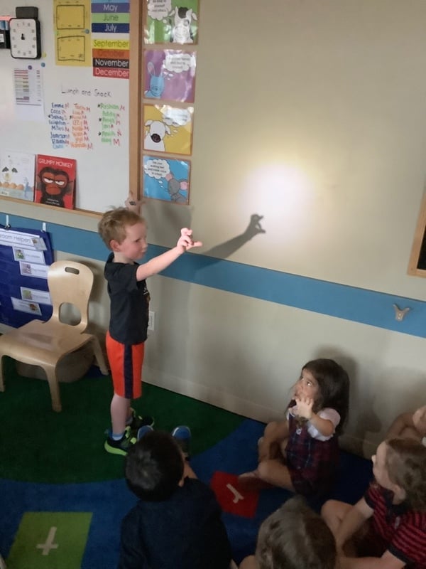 Pre-k student telling a story with light and shadow at Primrose Dublin Riverside