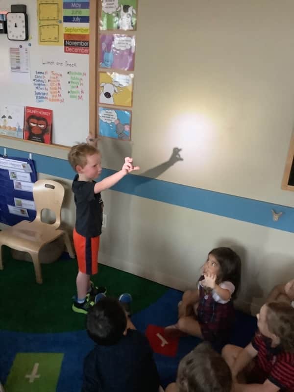 Pre-k student telling a story with light and shadow at Primrose Dublin Riverside