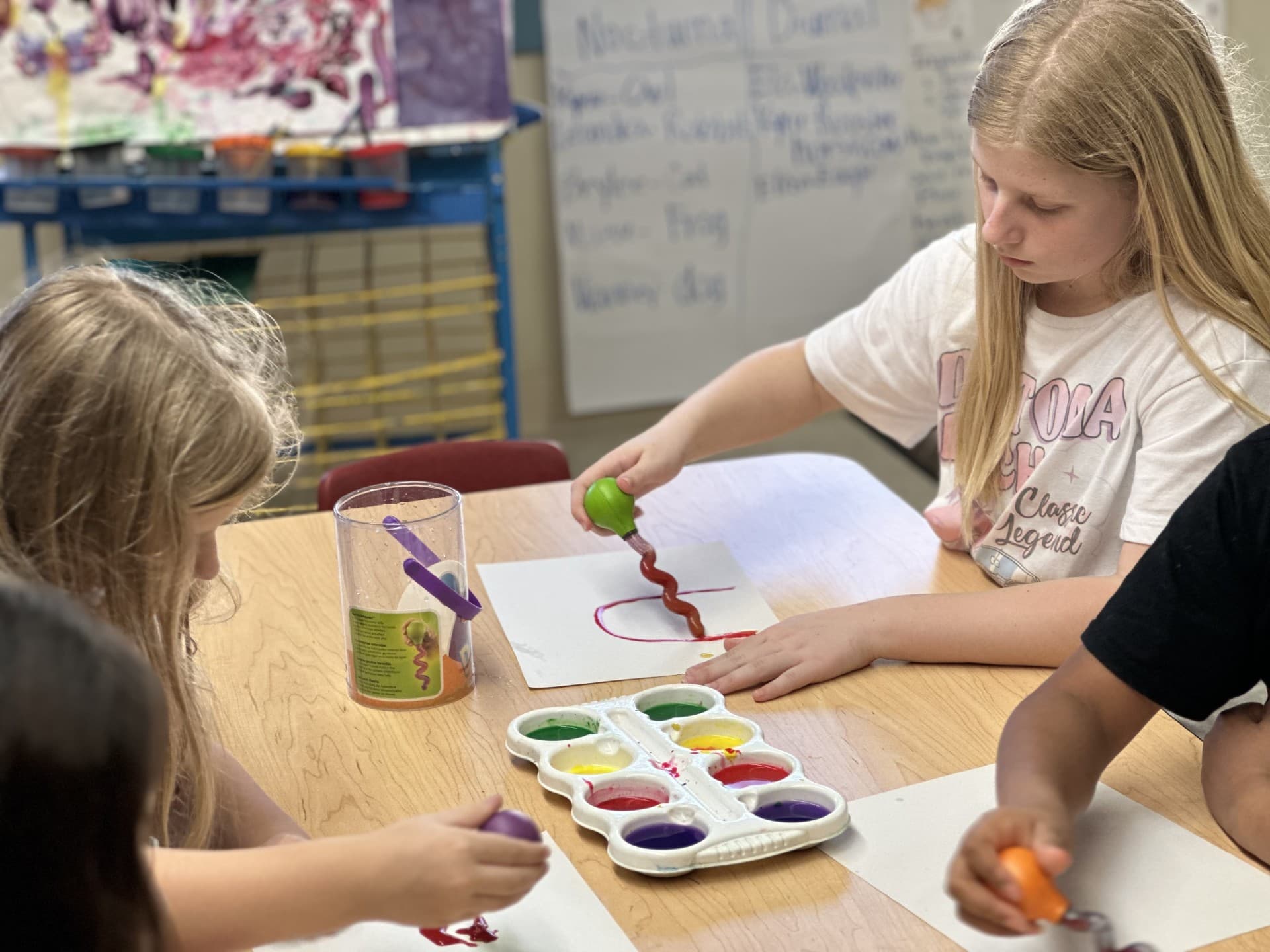 Elementary students using spiral painting tools to create colorful artwork while exploring creativity and fine motor skills.