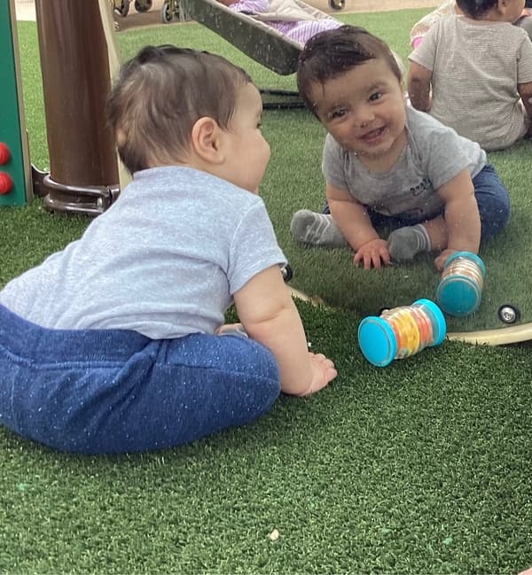 smiling baby looking in mirror