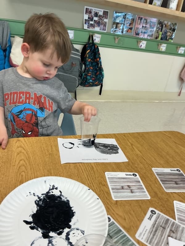 Boy using a cup to paint