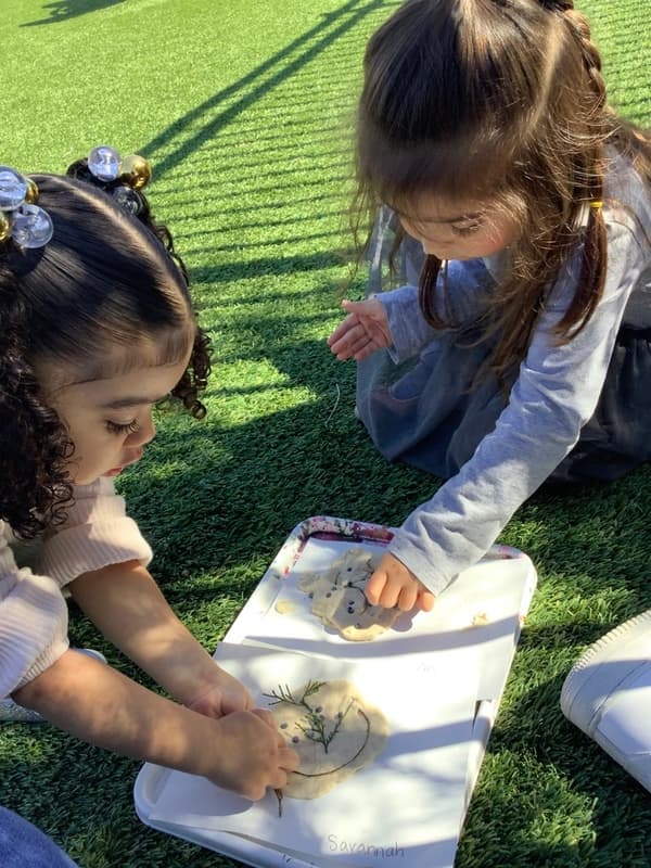 Preschool students using natural materials in an outdoor sensory activity