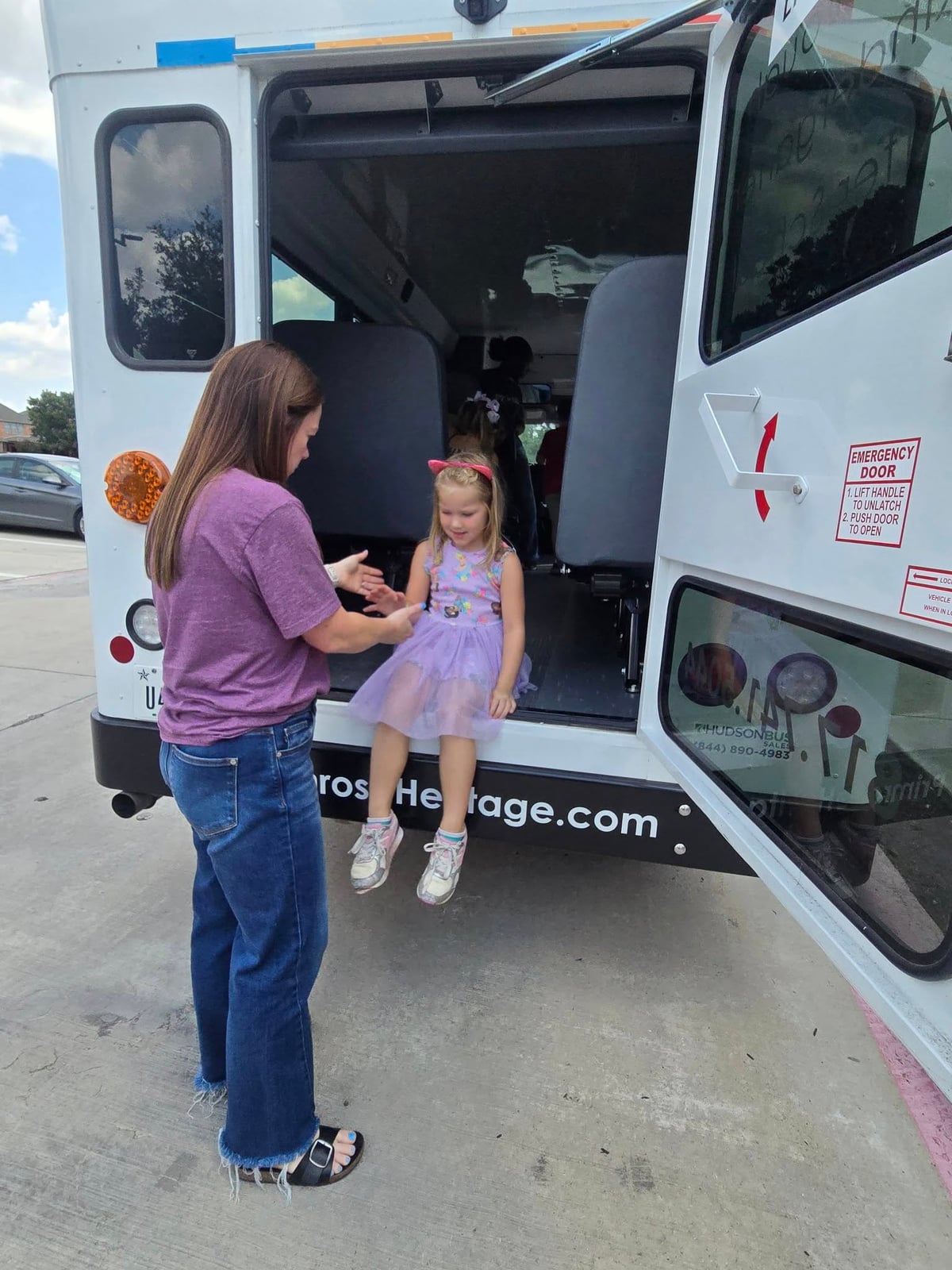 Primrose School director assisting an Explorer student during a bus evacuation drill in Keller, Texas the first week of school