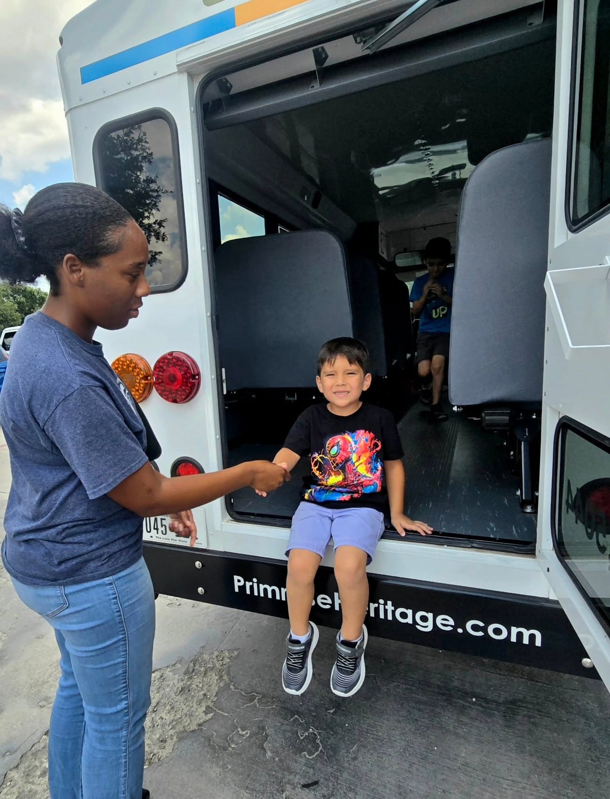 Primrose School teacher assisting an Explorer student during a bus evacuation drill in Keller, Texas the first week of school