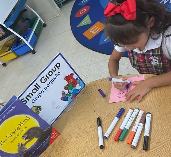 pre-k student working on writing and drawing skills