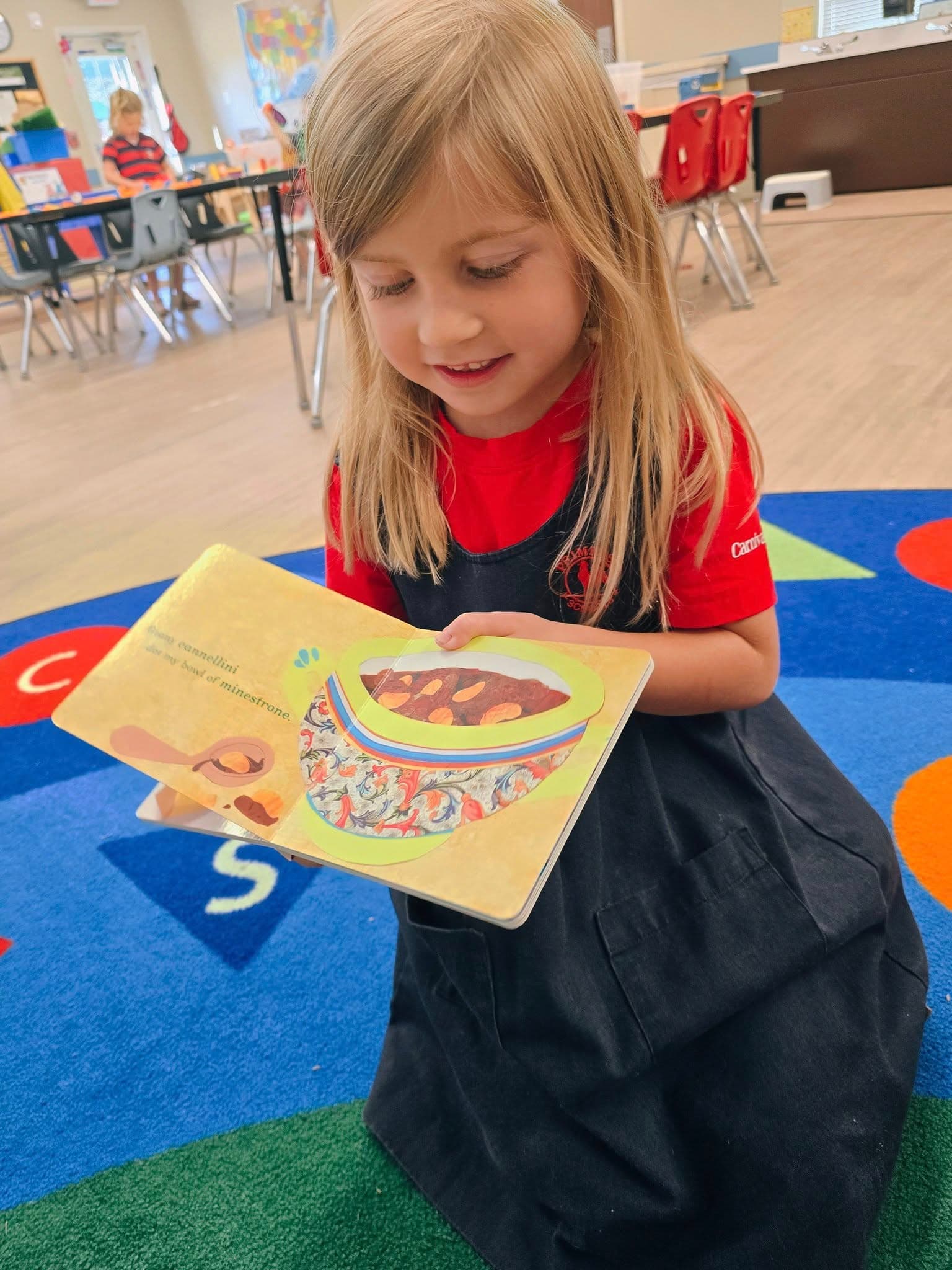 Pre-Kindergarten students exploring books about food from different cultures at a preschool in Keller, Texas 76244.