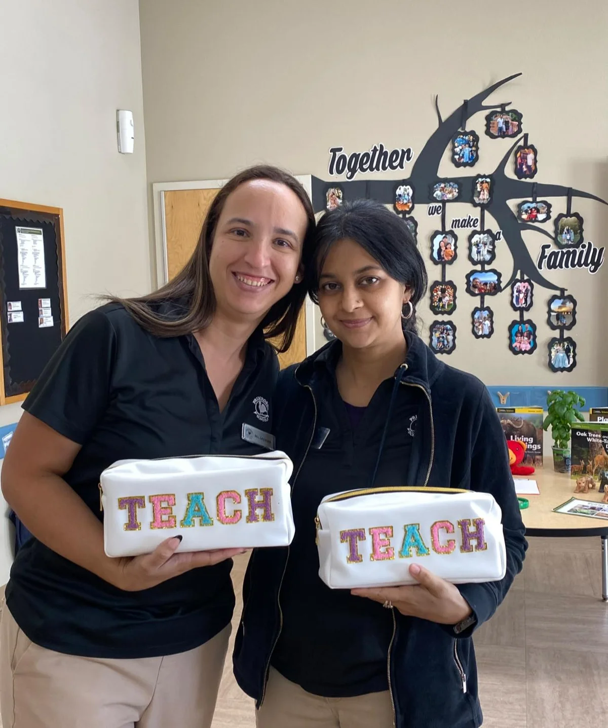 two women with black polos and khaki pants holding white bags that say teach