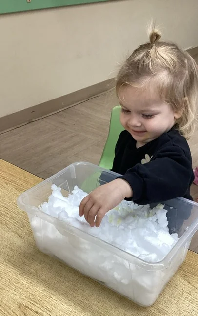 child smiling playing in the snow