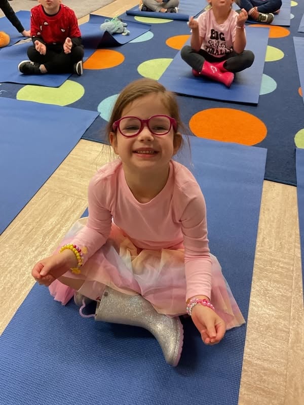 Preschool student smiles during a classroom mindfulness and movement activity that promotes focus, balance, and social-emotional development at Primrose School.