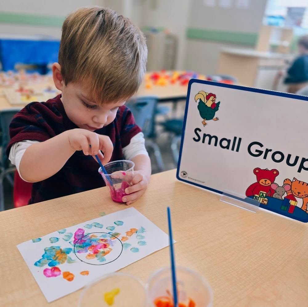 Child engaged in a small group art project, exploring materials and developing creativity during an early learning activity at Primrose Heritage in Keller, TX.