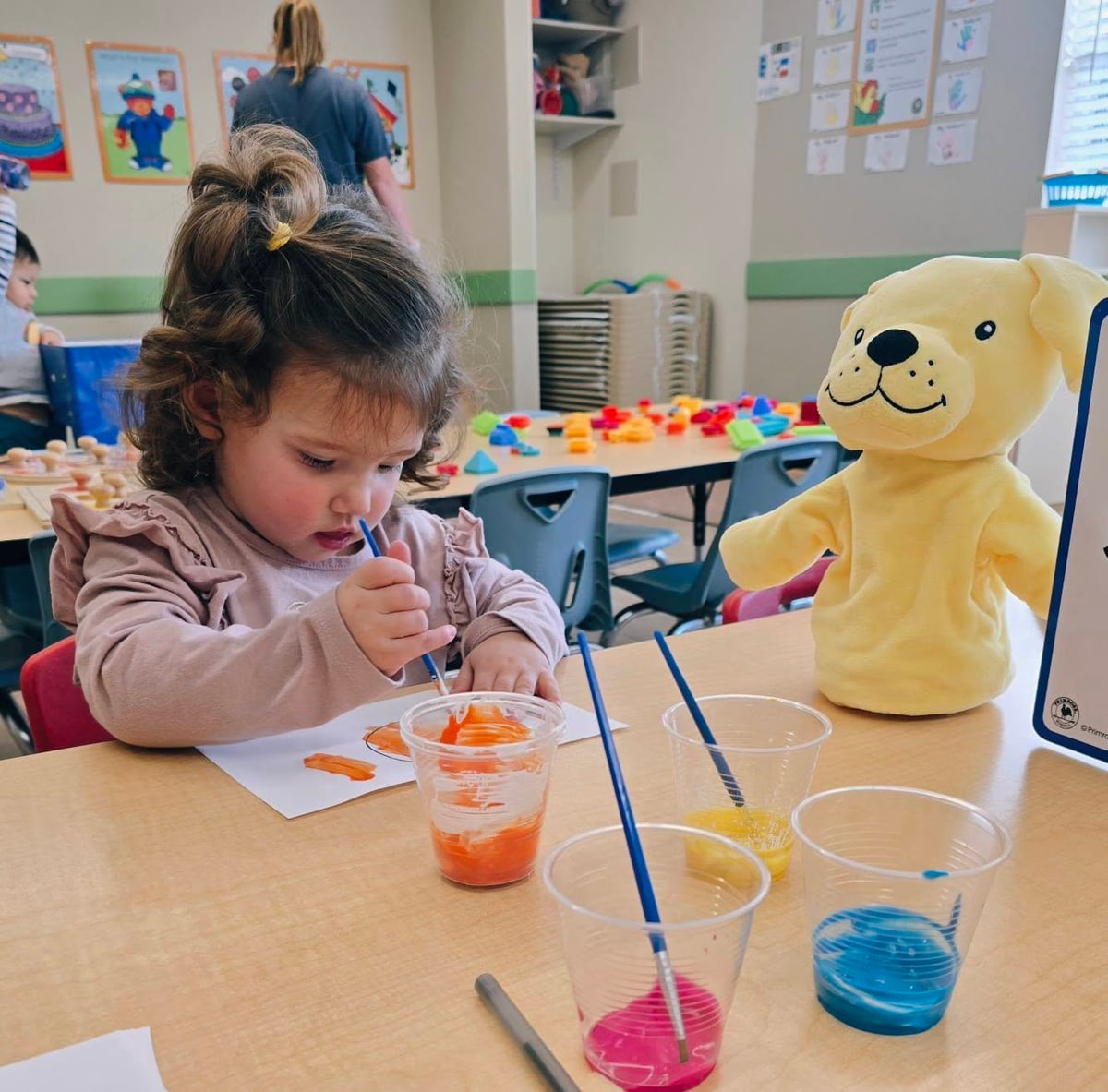Child engaged in a small group art project, exploring materials and developing creativity during an early learning activity at Primrose Heritage in Keller, TX.