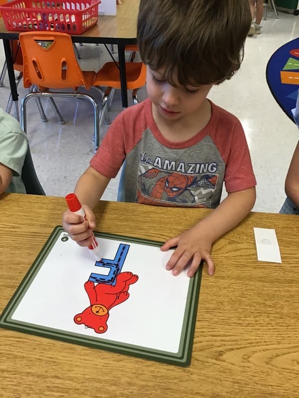 Boy tracing the letter "F"